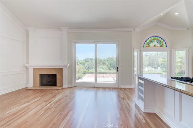 a view of empty room with wooden floor and a fireplace