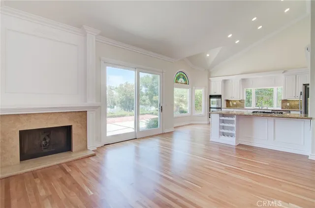a view of a kitchen with wooden floor and a fireplace