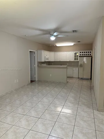 a kitchen with a sink a refrigerator and cabinets