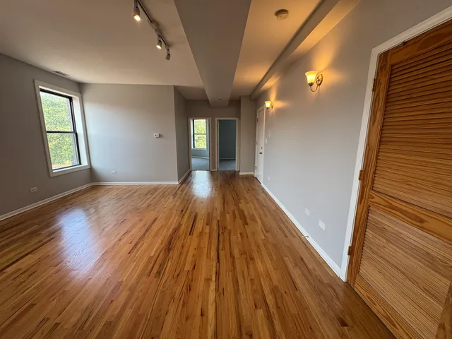 a view of a hallway with wooden floor and staircase