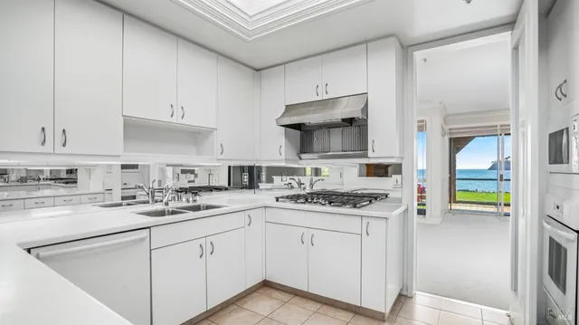 a kitchen with cabinets appliances a sink and a counter top space