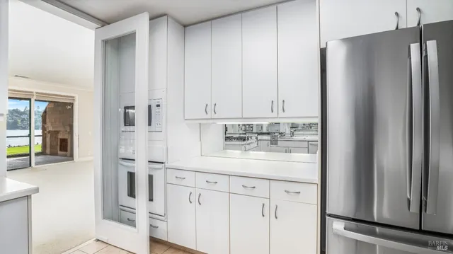 a kitchen with stainless steel appliances white cabinets and a refrigerator