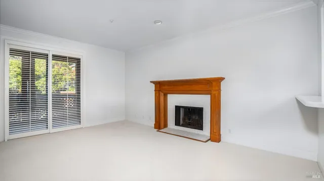 a view of an empty room with a fireplace and a window