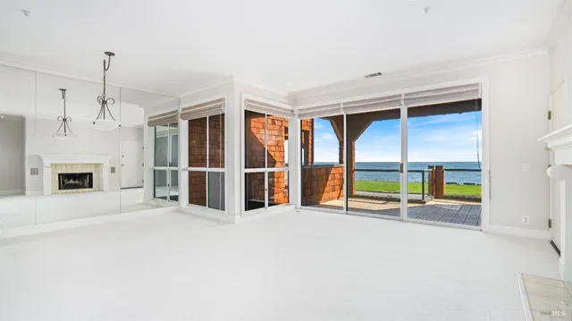 a view of an empty room with a fireplace and a window