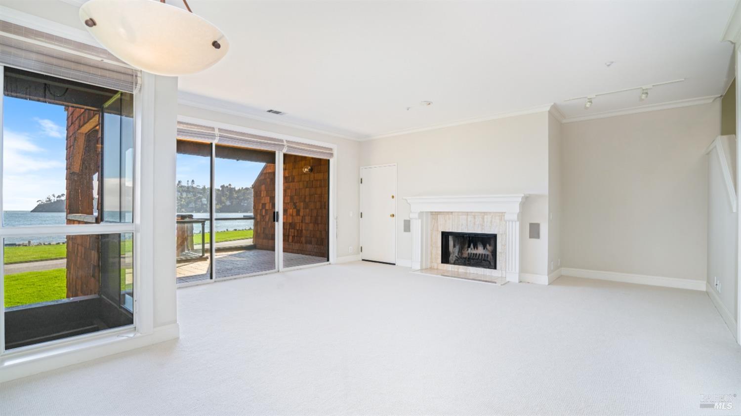 206 Paradise Drive Tiburon, CA 94920 - Photo 8 of 45 a view of an empty room with a fireplace and a window