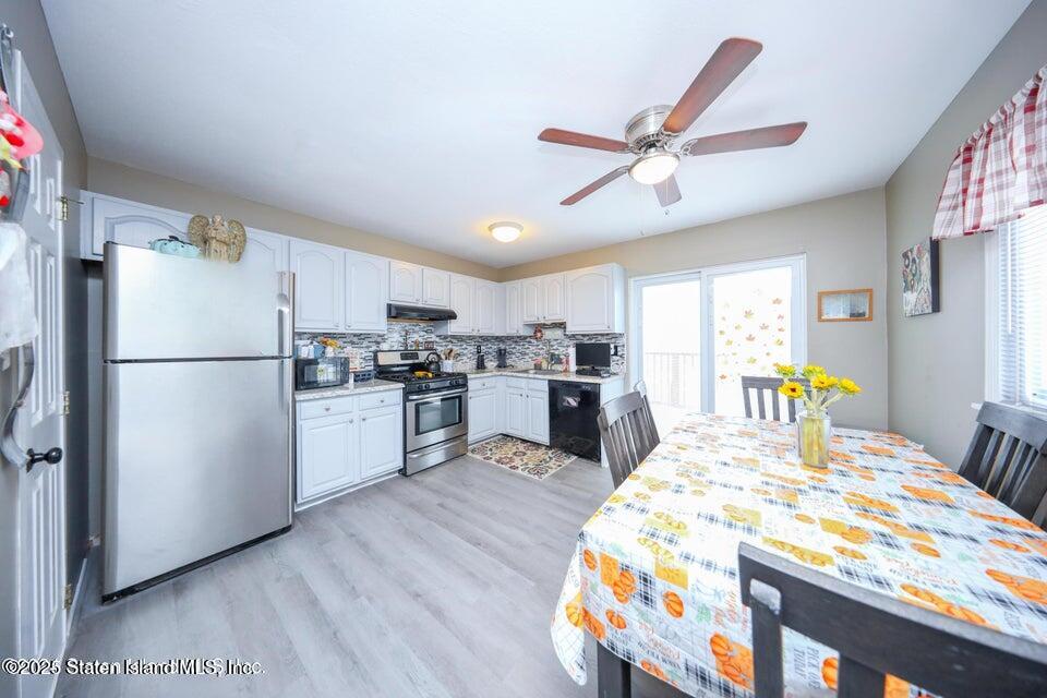 69 Token Street Staten Island, NY 10312 - Photo 11 of 22 a kitchen with stainless steel appliances granite countertop a refrigerator a microwave oven a sink with island and chairs