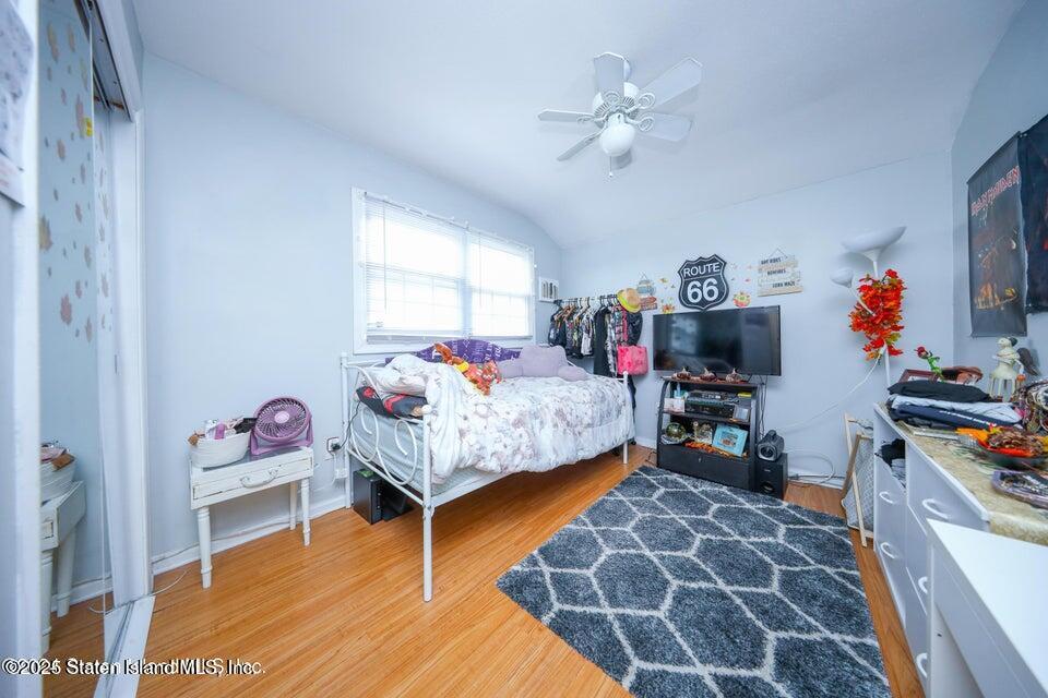 69 Token Street Staten Island, NY 10312 - Photo 15 of 22 a bedroom with a bed and a chandelier