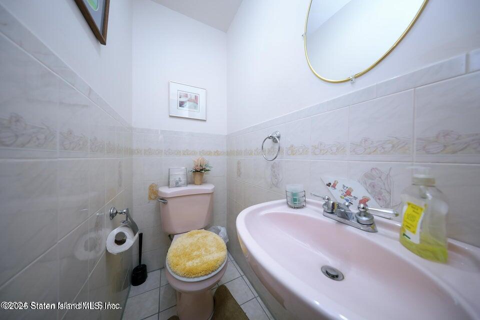 69 Token Street Staten Island, NY 10312 - Photo 17 of 22 a bathroom with a sink a toilet and a mirror