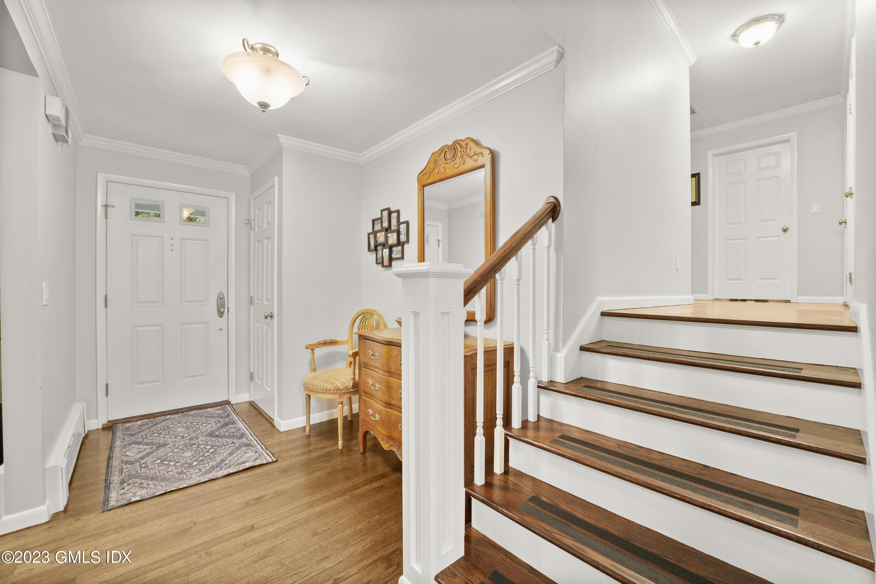 21 Barton Lane Cos Cob, CT 06807 - Photo 2 of 22 a view of entryway with wooden floor and stairs
