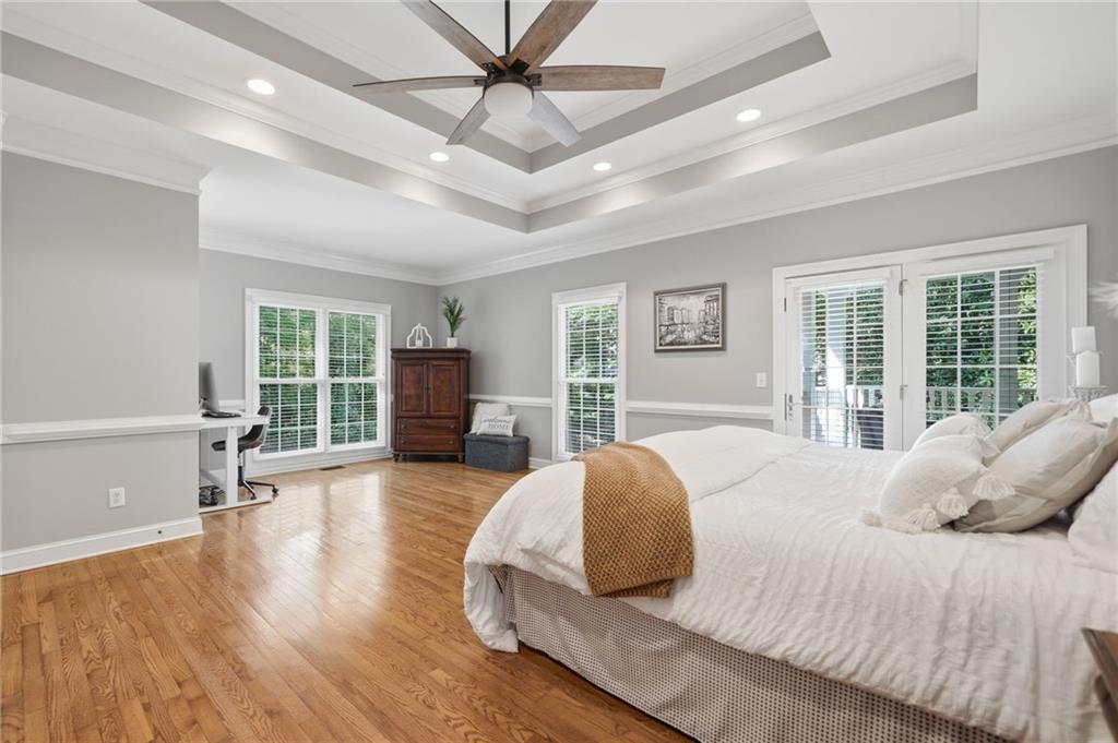 153 York Place Calhoun, GA 30701 - Photo 20 of 78 a spacious bedroom with a large bed a flat tv screen and wooden floor