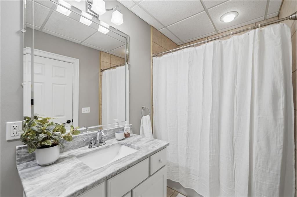 153 York Place Calhoun, GA 30701 - Photo 43 of 78 a bathroom with a granite countertop sink a mirror and a shower curtain