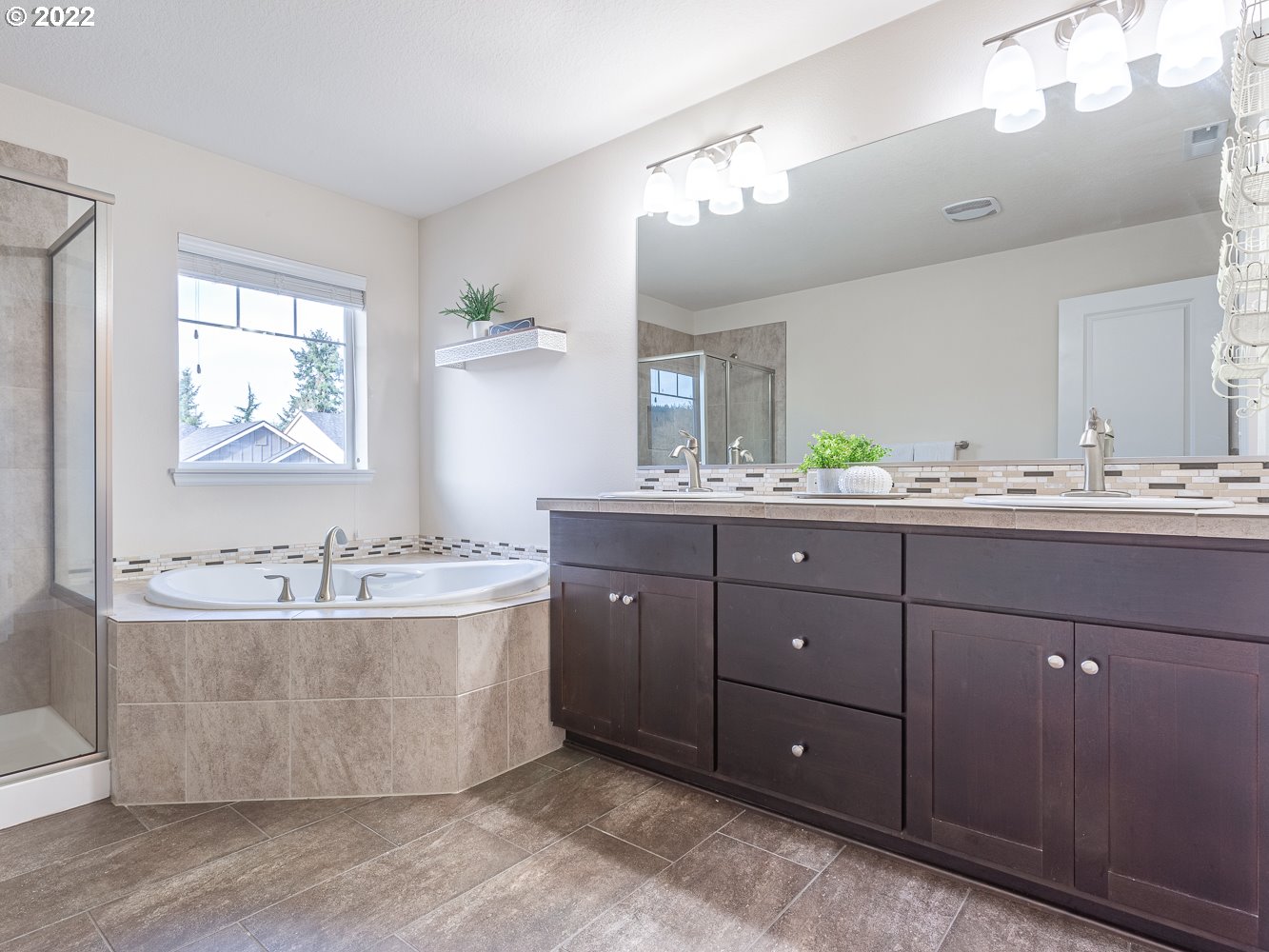 17656 Southeast Pinnacles Street Damascus, OR 97089 - Photo 16 of 31 a bathroom with a tub double vanity sink and mirror