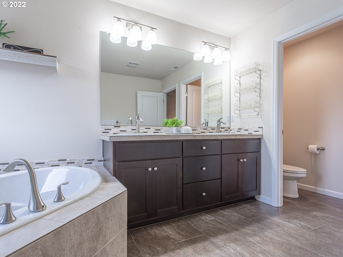 17656 Southeast Pinnacles Street Damascus, OR 97089 - Photo 17 of 31 a spacious bathroom with a double vanity sink double mirror and toilet