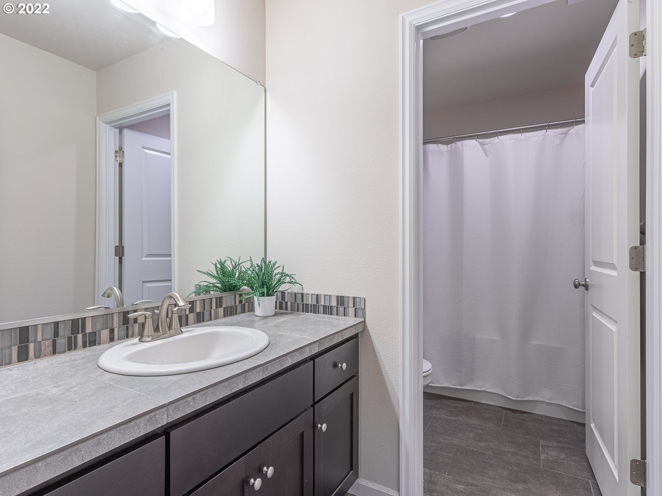 17656 Southeast Pinnacles Street Damascus, OR 97089 - Photo 21 of 31 a bathroom with a granite countertop sink and a mirror
