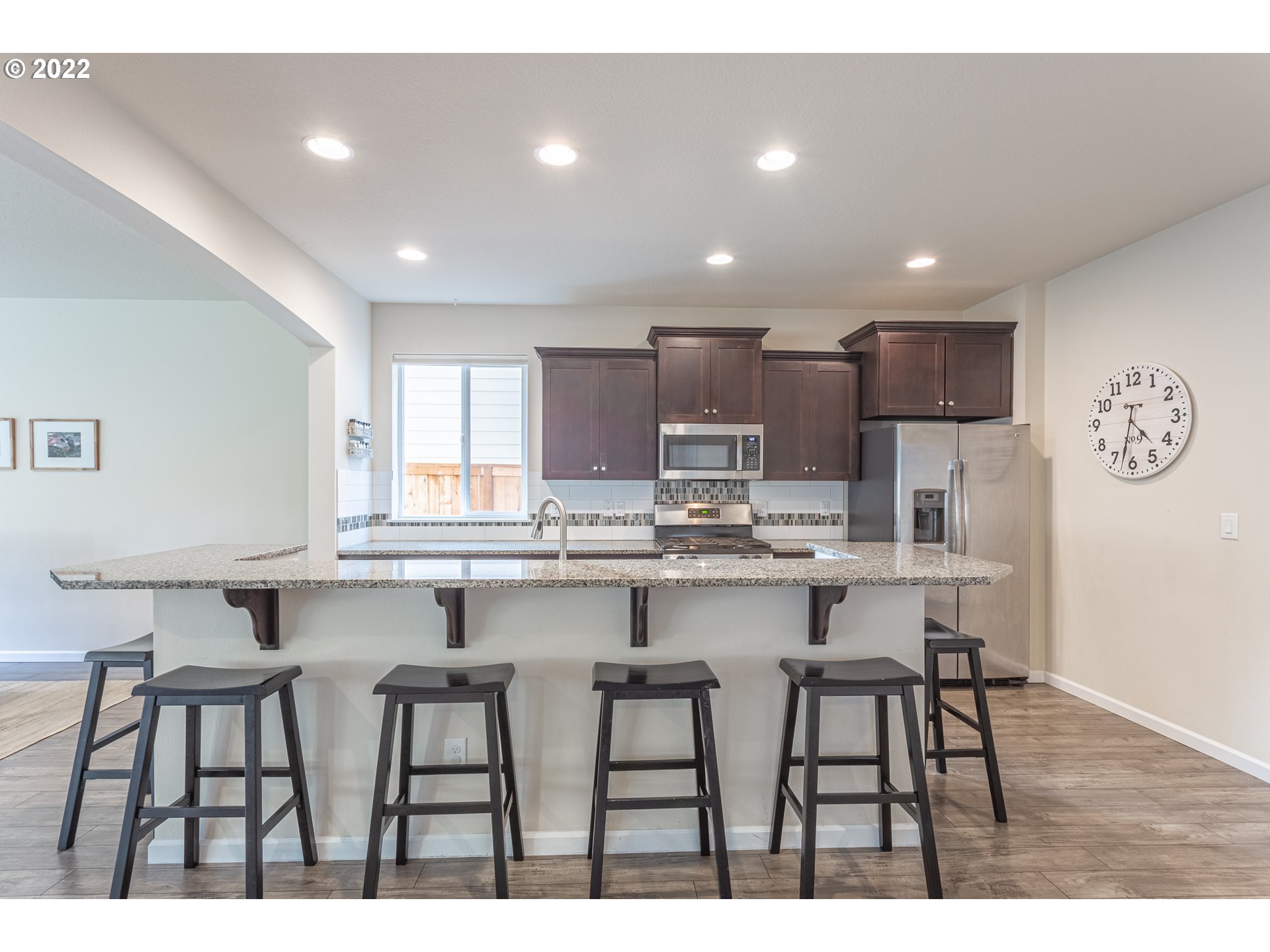 17656 Southeast Pinnacles Street Damascus, OR 97089 - Photo 3 of 31 a kitchen with kitchen island cabinets and chairs in it