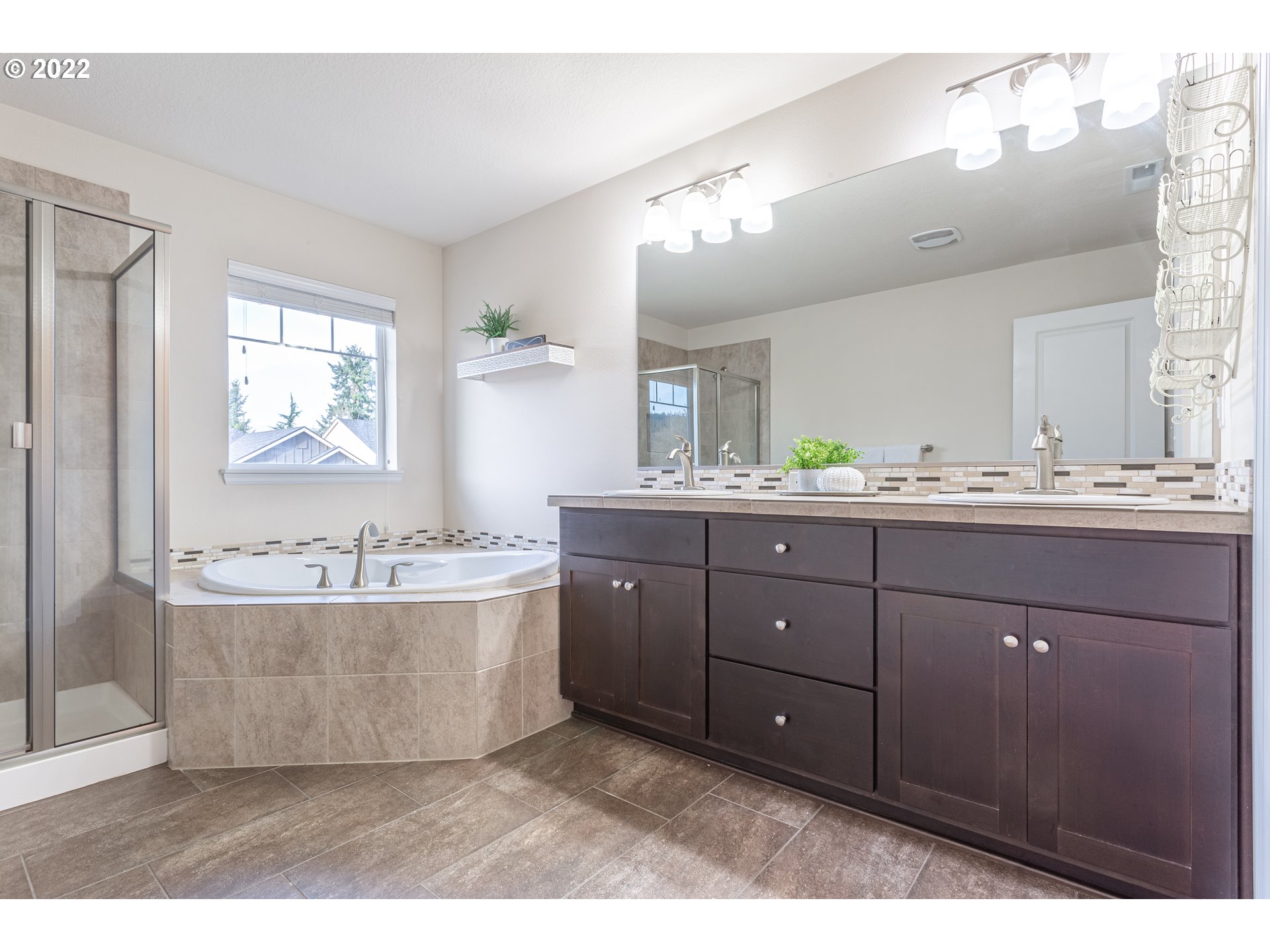 17656 Southeast Pinnacles Street Damascus, OR 97089 - Photo 6 of 31 a bathroom with a tub sink double vanity and mirror
