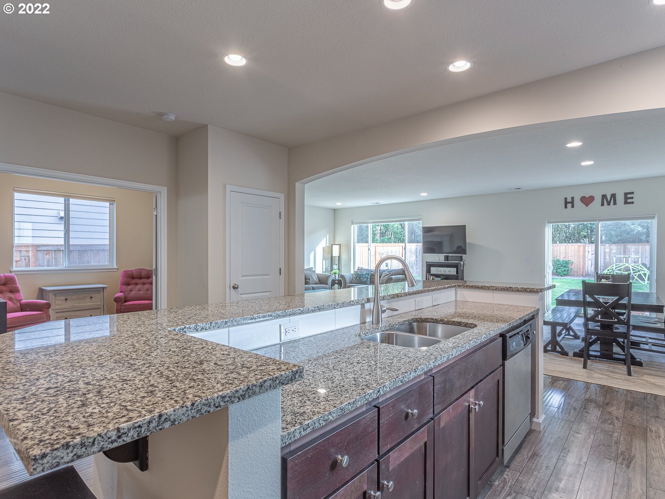 17656 Southeast Pinnacles Street Damascus, OR 97089 - Photo 7 of 31 a kitchen with granite countertop a sink and a wooden floor