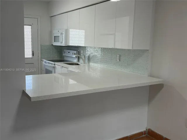 a close view of a sink a counter space and cabinets in a room