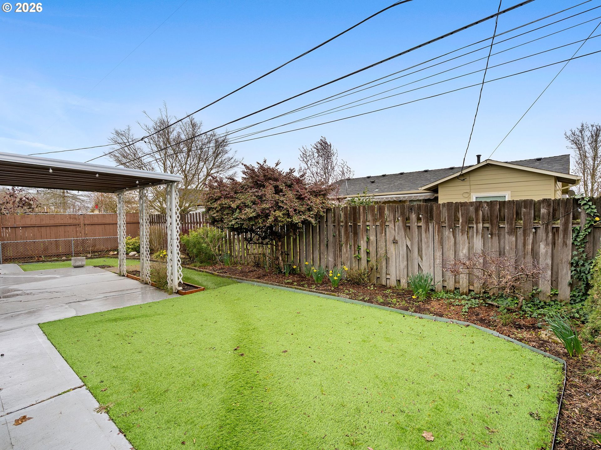 2036 Sallal Road Woodburn, OR 97071 - Photo 24 of 25 a yellow house with a yard and wooden fence