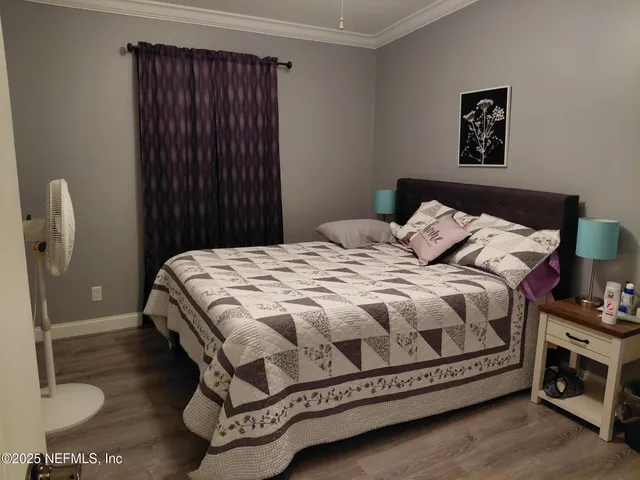 a bed sitting in a bedroom next to a bathroom with a sink