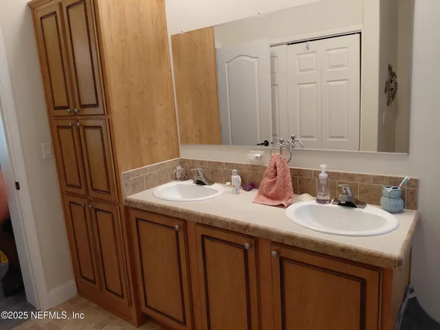 a bathroom with double sink and a mirror