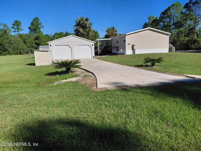 a view of a house with a yard and garage