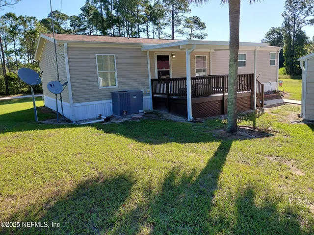 a view of house with backyard and furniture