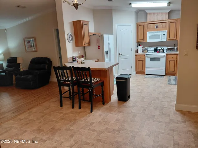 a living room with stainless steel appliances kitchen island granite countertop furniture and a refrigerator
