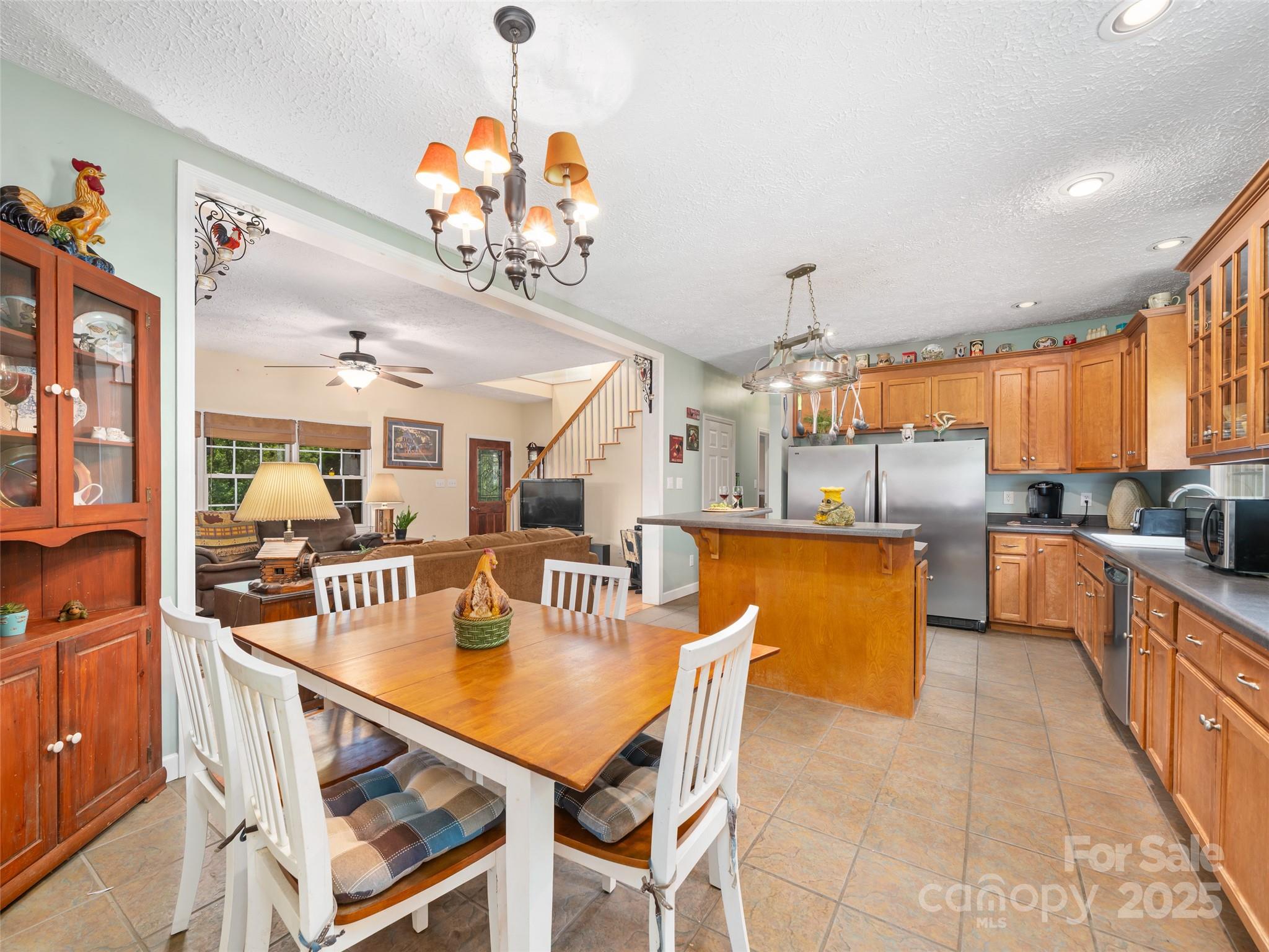 2216 Beans Creek Road Bakersville, NC 28705 - Photo 11 of 39 a view of a dining room and livingroom with furniture wooden floor a rug a flat screen tv a rug and a chandelier