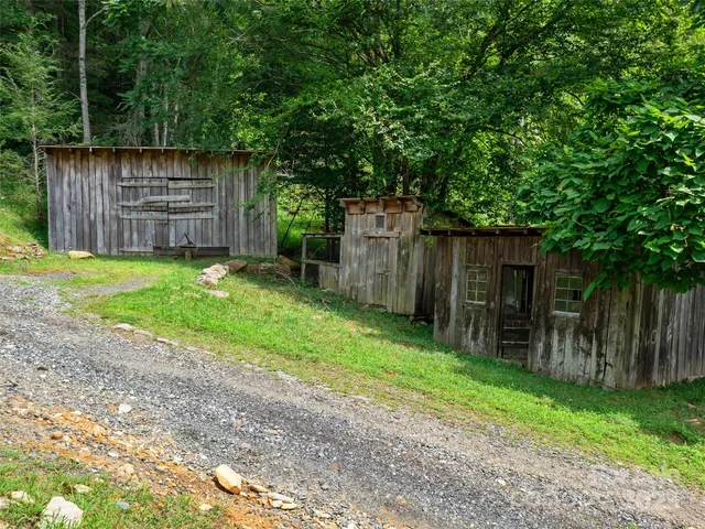 a backyard of a house with a small barn and wooden fence
