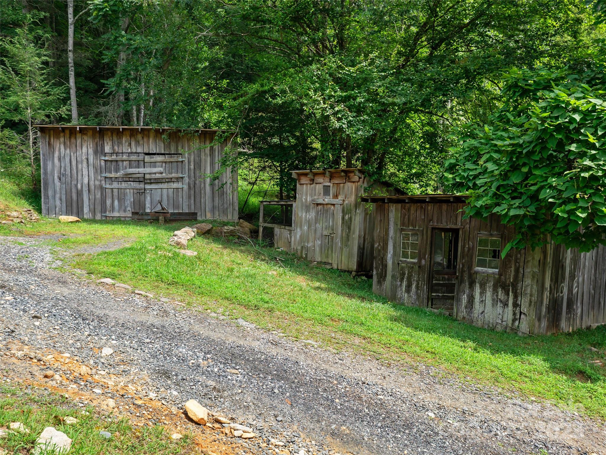 2216 Beans Creek Road Bakersville, NC 28705 - Photo 29 of 39 a backyard of a house with a small barn and wooden fence