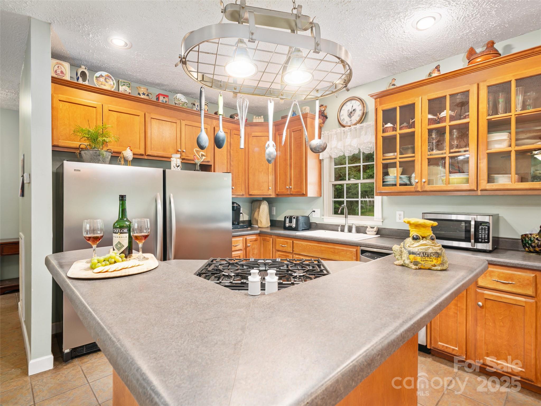2216 Beans Creek Road Bakersville, NC 28705 - Photo 9 of 39 a kitchen with a refrigerator a stove and a dining table with the view of kitchen