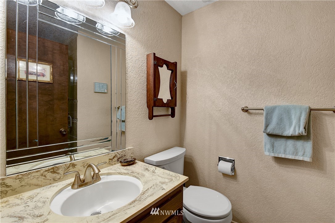 22217 61st Avenue Southeast Bothell, WA 98021 - Photo 26 of 37 a bathroom with a granite countertop sink toilet and mirror