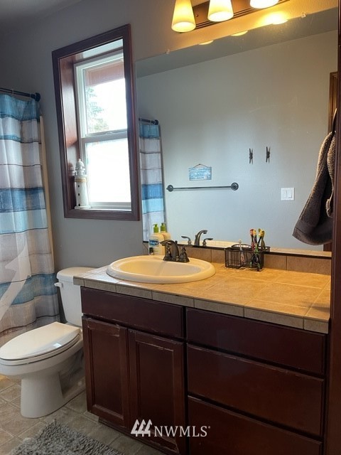 22217 61st Avenue Southeast Bothell, WA 98021 - Photo 36 of 37 a bathroom with a granite countertop sink a toilet and a bathtub