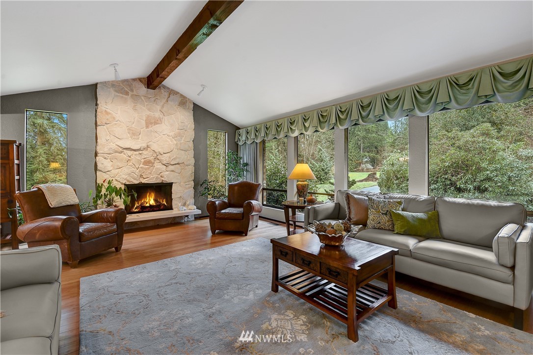 22217 61st Avenue Southeast Bothell, WA 98021 - Photo 5 of 37 a living room with furniture a fireplace and a floor to ceiling window