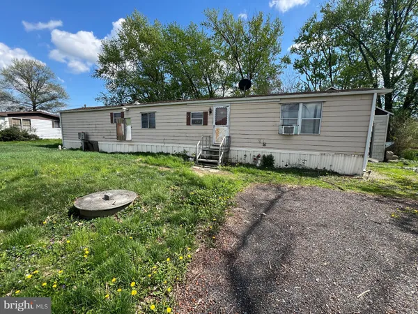 a backyard of a house with barbeque oven and trees