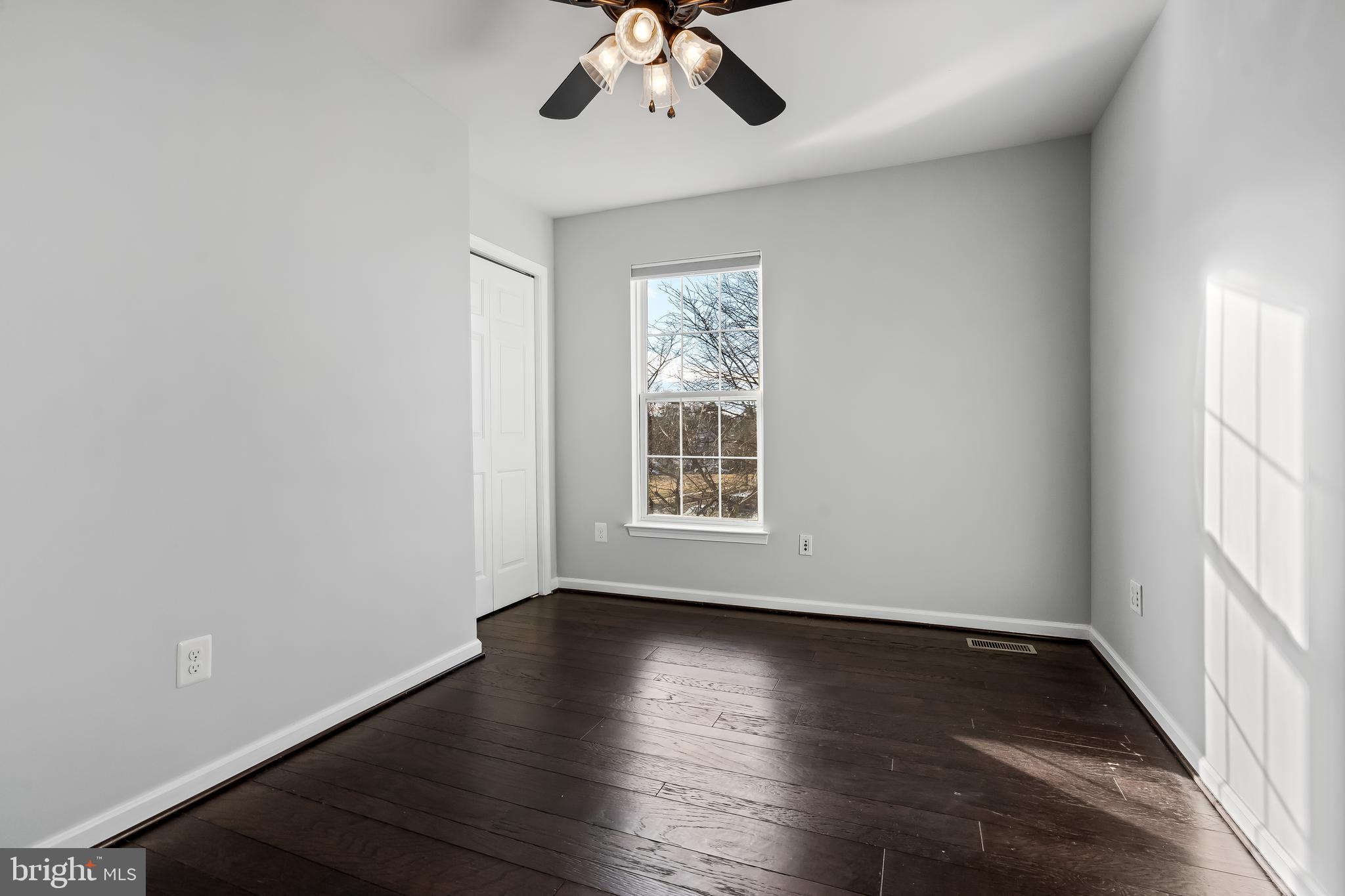 43112 Demerrit Street Chantilly, VA 20152 - Photo 32 of 42 an empty room with wooden floor chandelier fan and windows