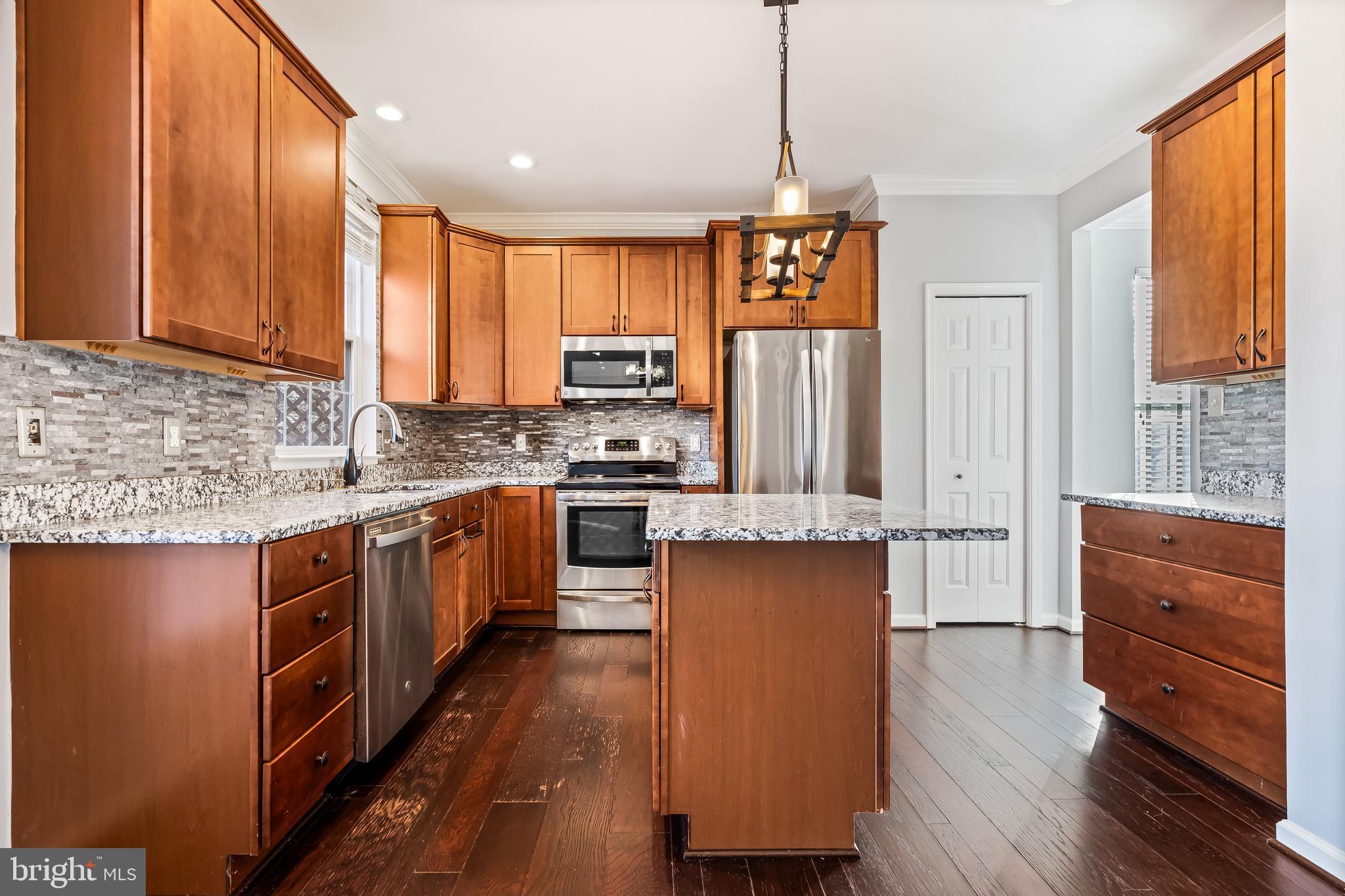 43112 Demerrit Street Chantilly, VA 20152 - Photo 9 of 42 a kitchen with stainless steel appliances granite countertop wooden cabinets a window and a sink