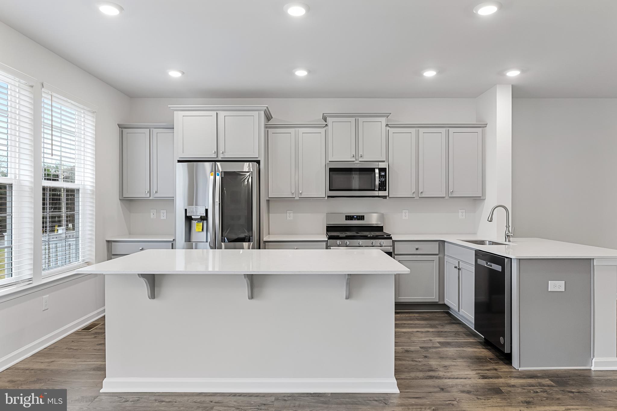 10 Sisters Farmstead Road Mount Laurel, NJ 08054 - Photo 15 of 35 a kitchen with stainless steel appliances granite countertop a stove a sink a refrigerator and white cabinets with wooden floor
