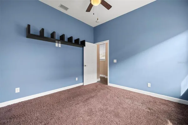 an empty room with closet and a chandelier fan
