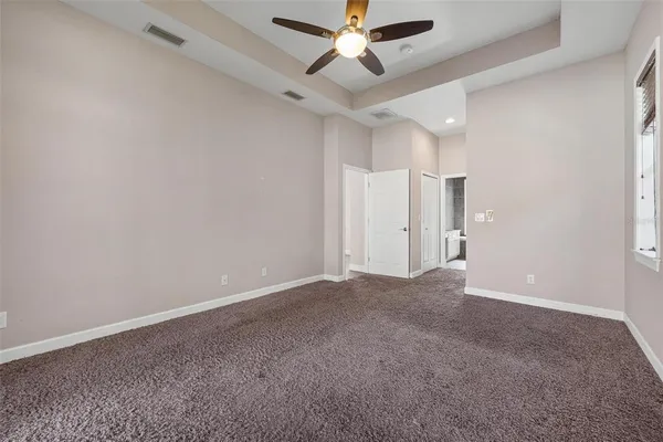an empty room with closet and a ceiling fan