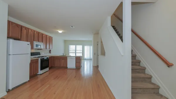 a view of a hallway with wooden floor and entryway