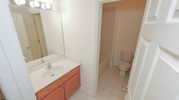a bathroom with a granite countertop sink a mirror and shower