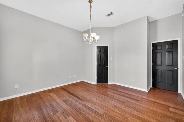 a big room with wooden floor and chandelier