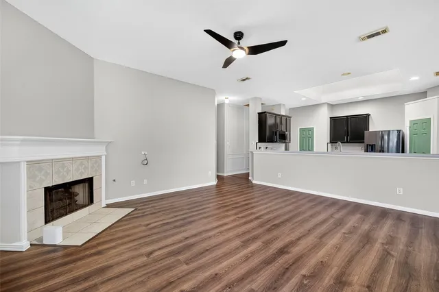 a view of a big room with wooden floor and a kitchen