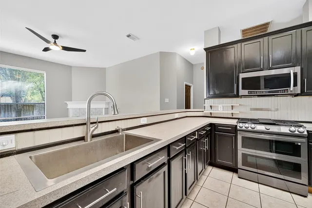 a kitchen with stainless steel appliances a sink stove and microwave