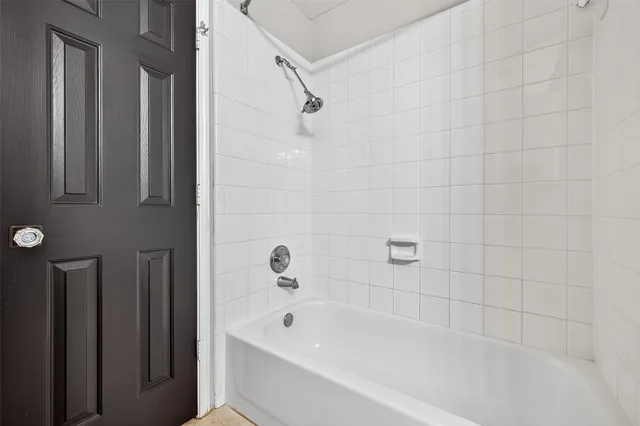 a view of a room with a large window wooden floor and front door