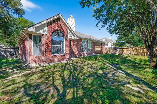 a backyard of a house with table and chairs