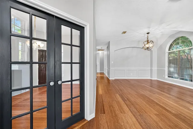 a view of empty room with wooden floor and fan