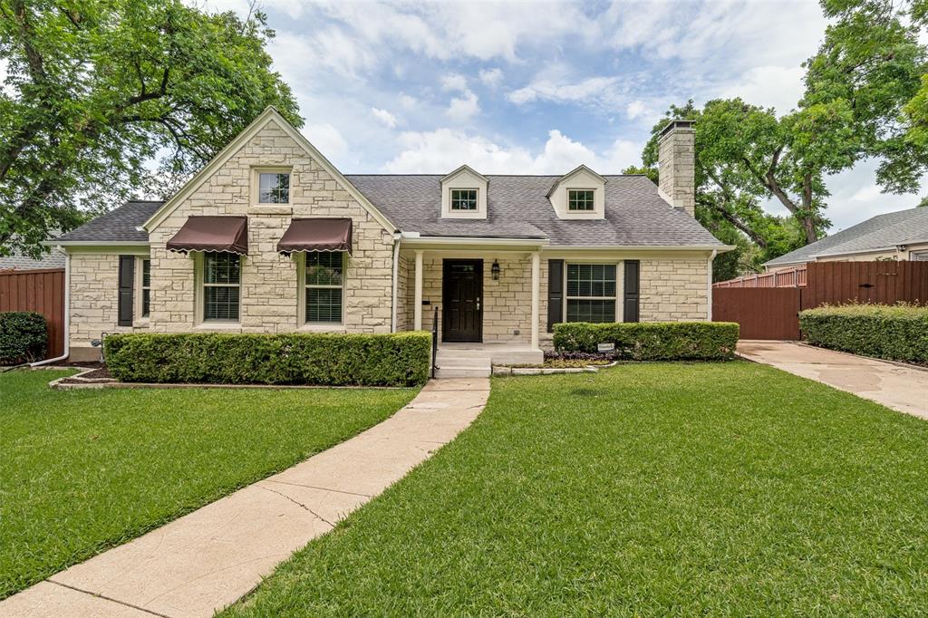 2006 Marydale Road Dallas, TX 75208 - Photo 1 of 40 Stone facade home featuring a covered front entry, dormer windows, decorative window awnings, and a well-defined concrete pathway